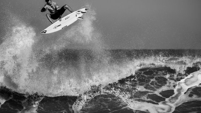 Surfer carving along a clean shoulder at sunset